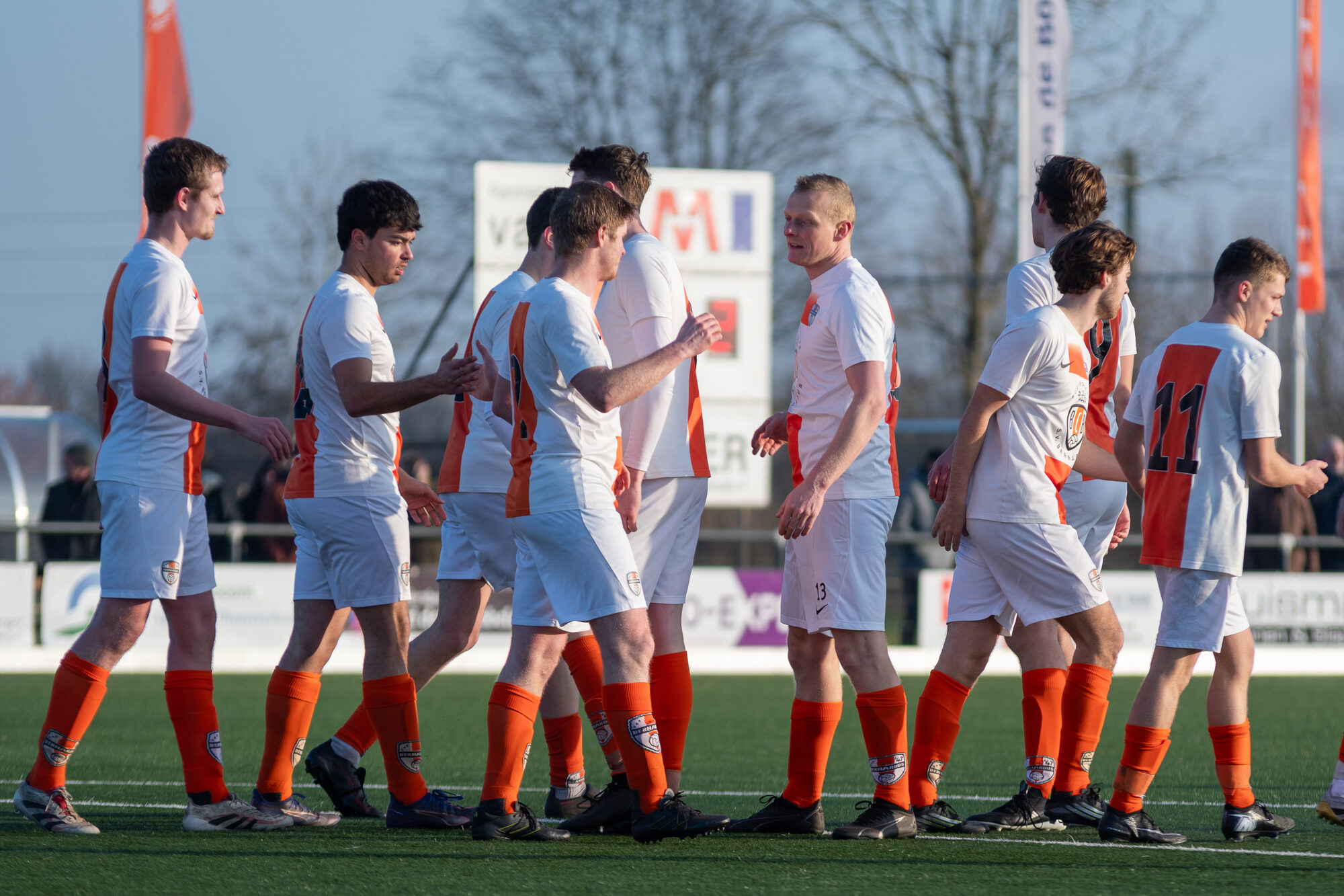 Spelers van SV Bernardus komen het veld op en begroeten elkaar